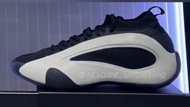 Side view of white and black adidas shoes.